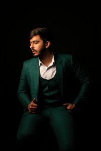 Stylish portrait of a man in a designer green suit. Studio lighting.